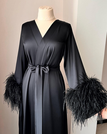 a black dress with feathers on a mannequin