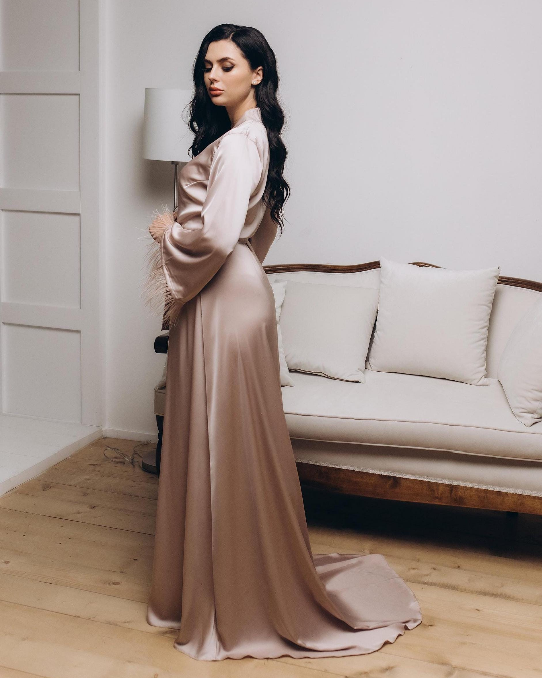 a woman standing in a living room wearing a dress
