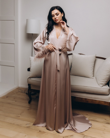 a woman standing in a living room wearing a dress