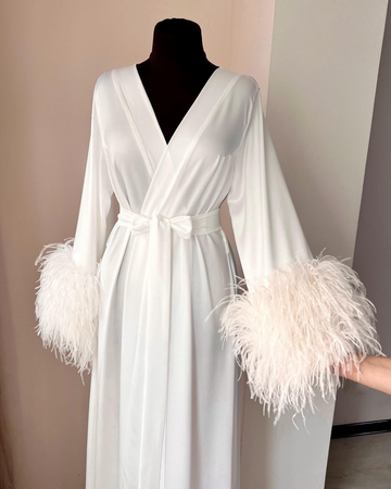 a white robe with feathers on the sleeves