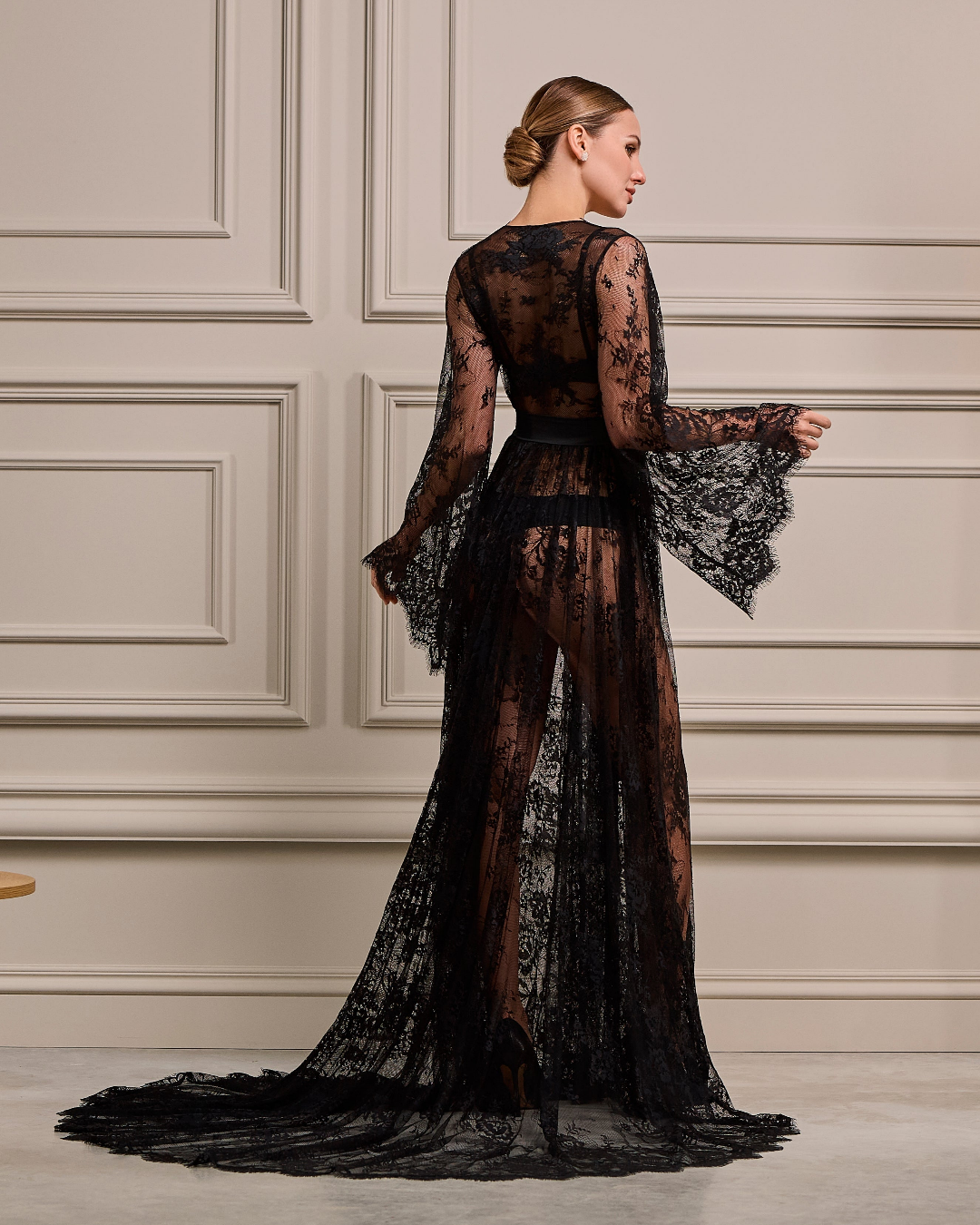 a woman in a black dress with a thigh high slit