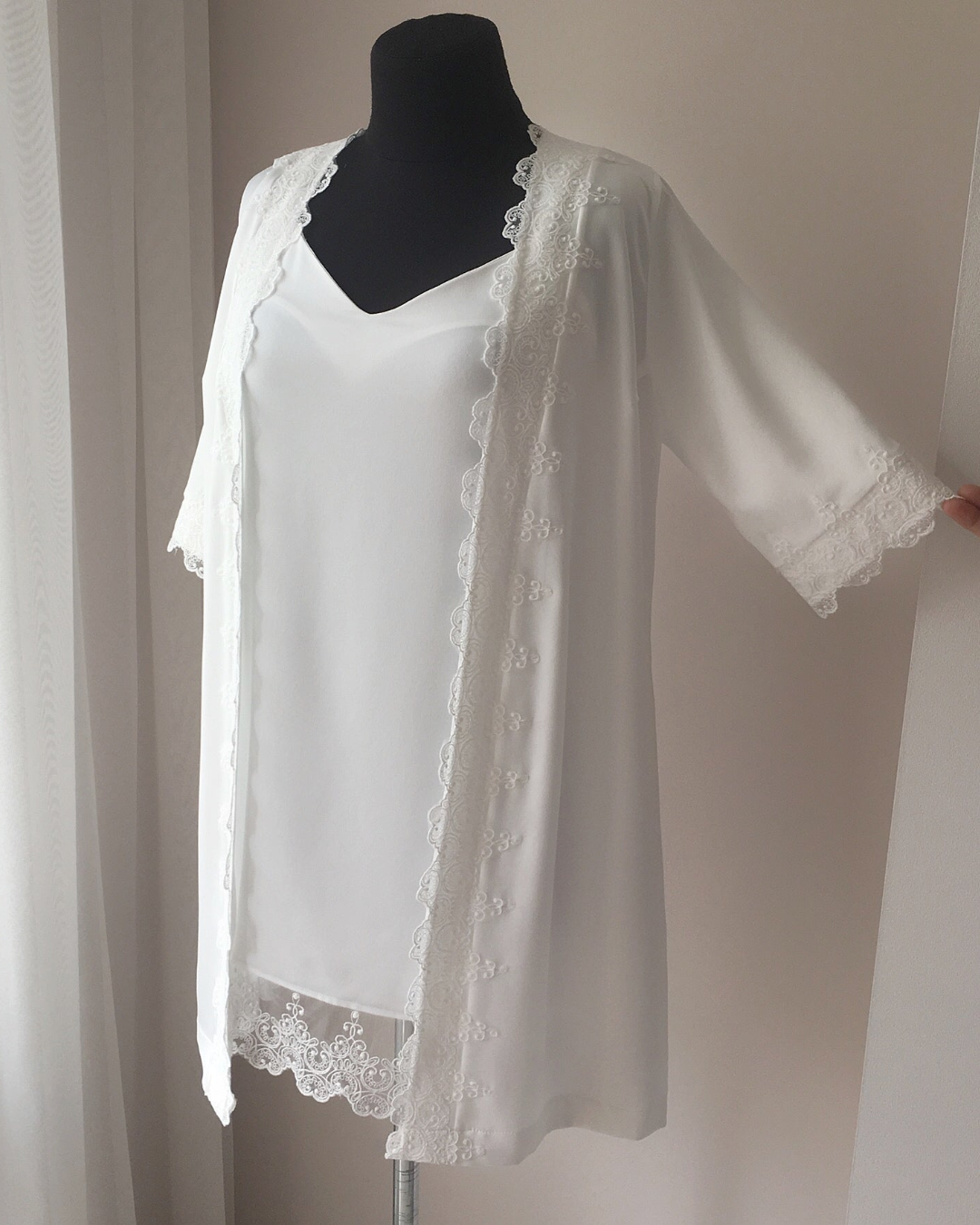 a white blouse with a lace trim on a mannequin