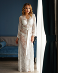 a woman in a white  lace robe  standing in a room