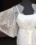 a white dress with a white sash on a mannequin