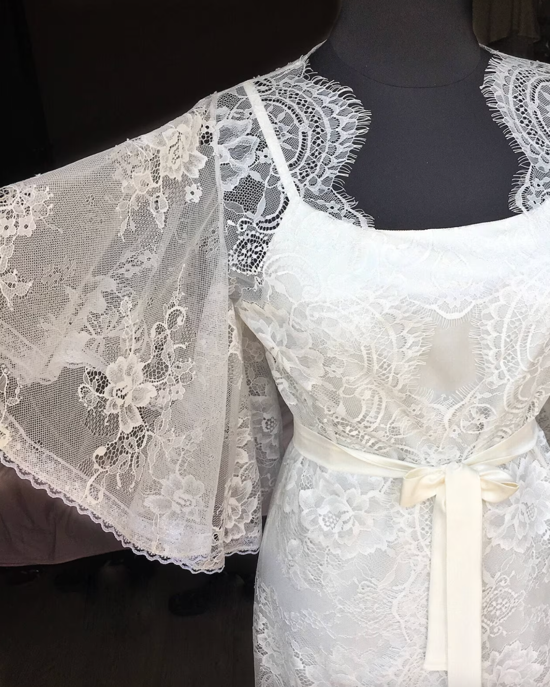 a white dress with a white sash on a mannequin