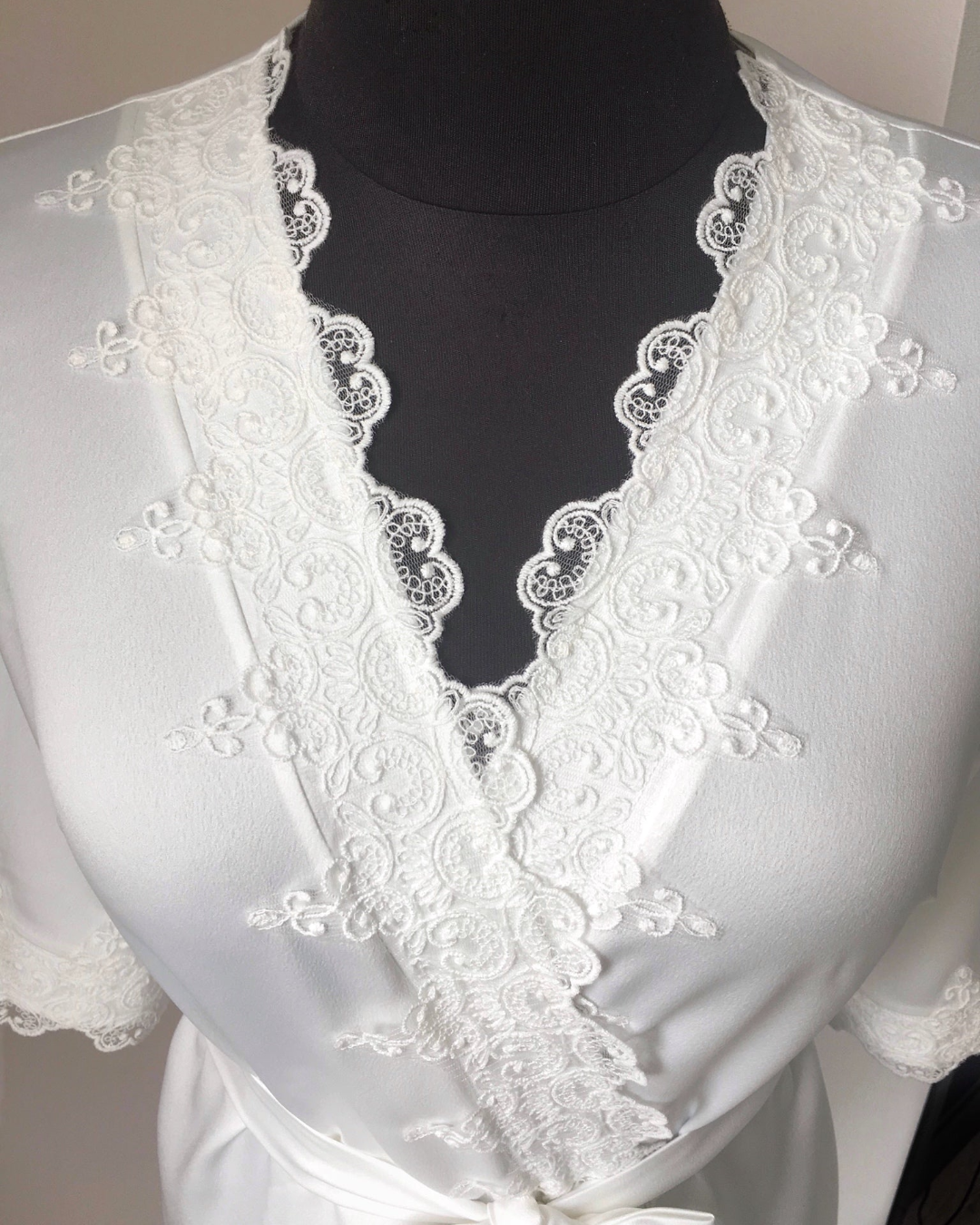 a woman wearing a white dress with a white bow tie