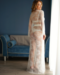 a woman in a  lace robe standing in front of a blue couch