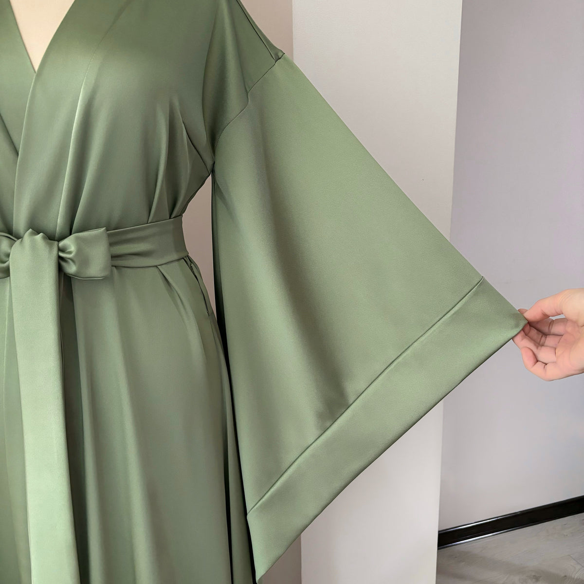 Olive green satin kimono sleeve detail with neat hem