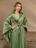 Model in a green silk kimono robe with wide sleeves and tie belt at the waist