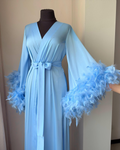 a woman's blue dress with feathers on it