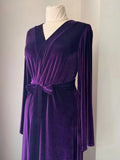 Front detail of V-neck purple velvet robe with matching belt and long sleeves.