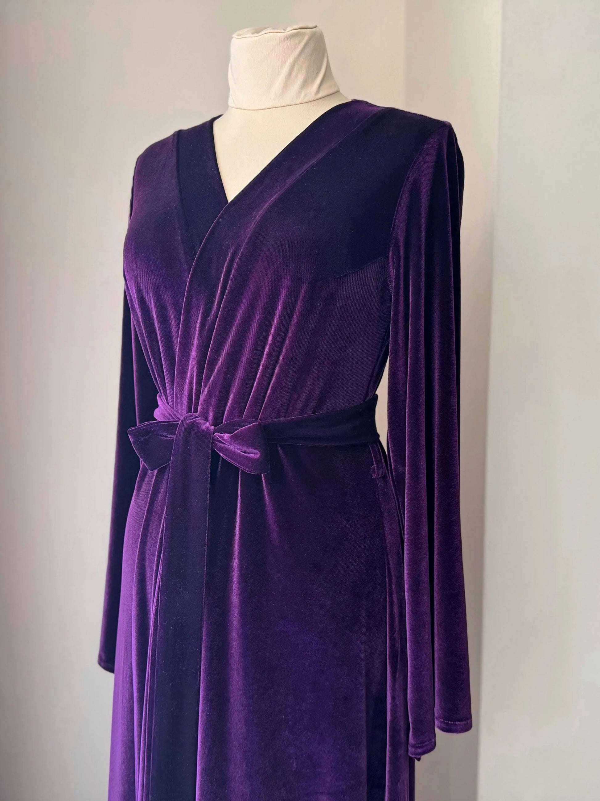 Front detail of V-neck purple velvet robe with matching belt and long sleeves.