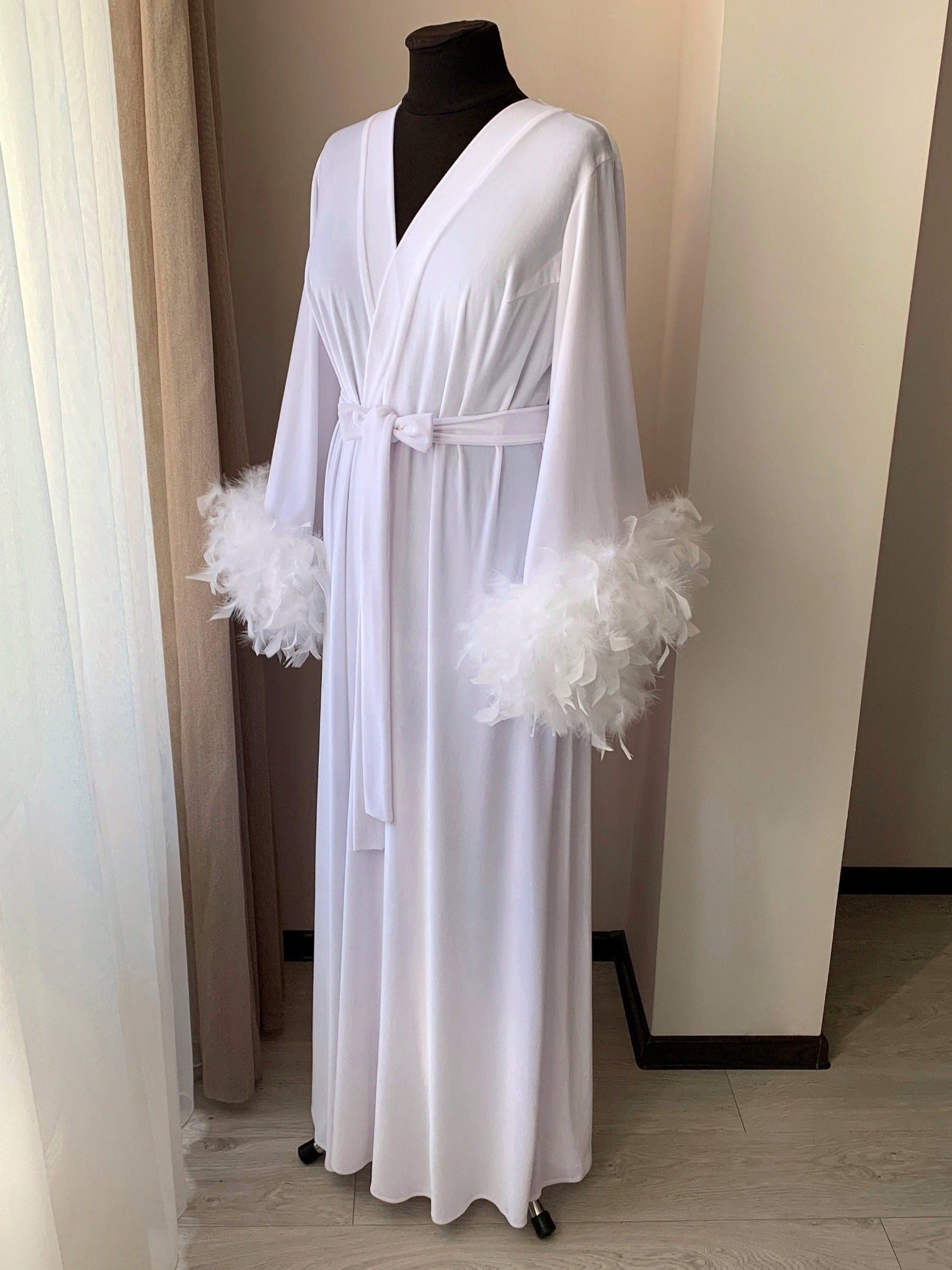 Close-up of double-row feather cuff on white velvet robe