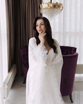 a woman in a white dress posing for a picture