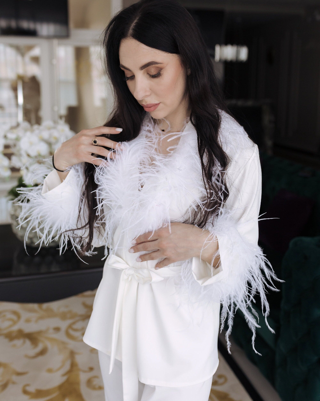 a woman in a white outfit sitting on a green couch