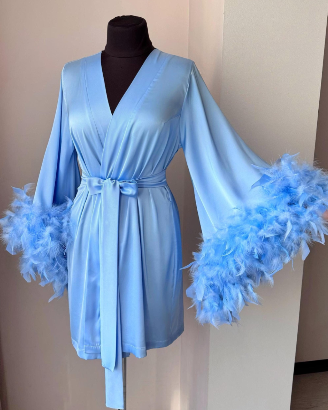 a blue robe with feathers on a mannequin