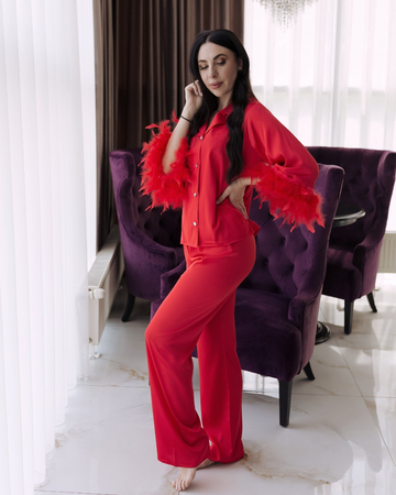 a woman in a red outfit standing in front of a purple chair