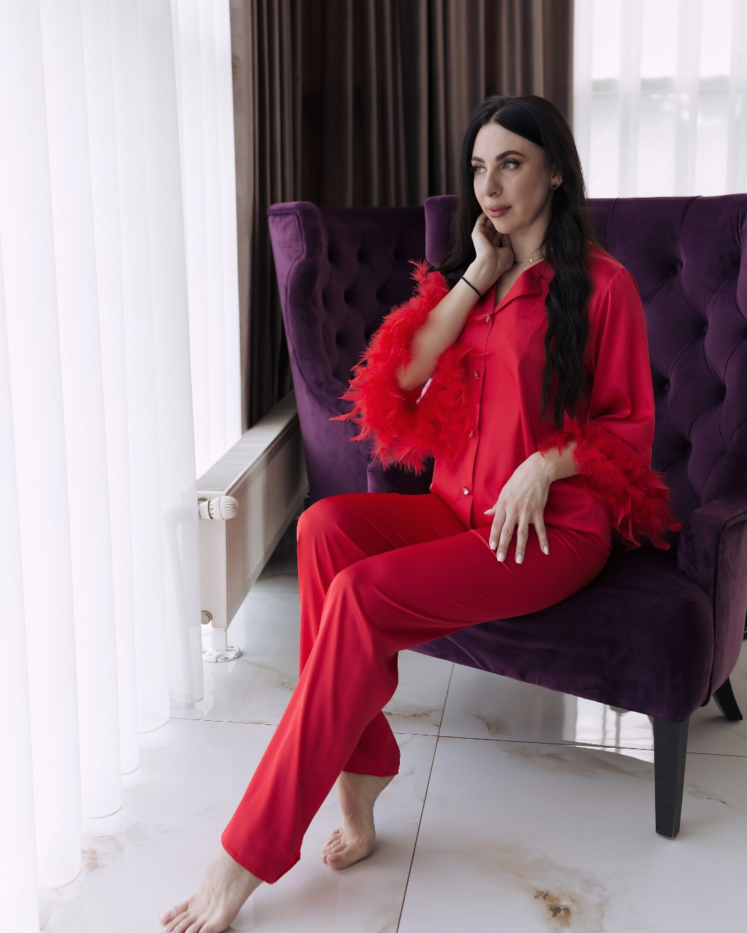 a woman in red is sitting on a purple chair