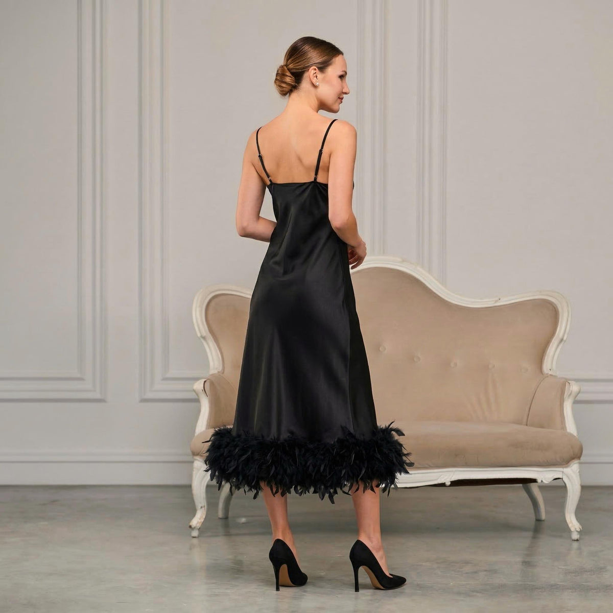 Back view of black satin midi slip dress with feather trim