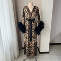 Luxury leopard print robe with feather trim shown in a flowing kimono silhouette