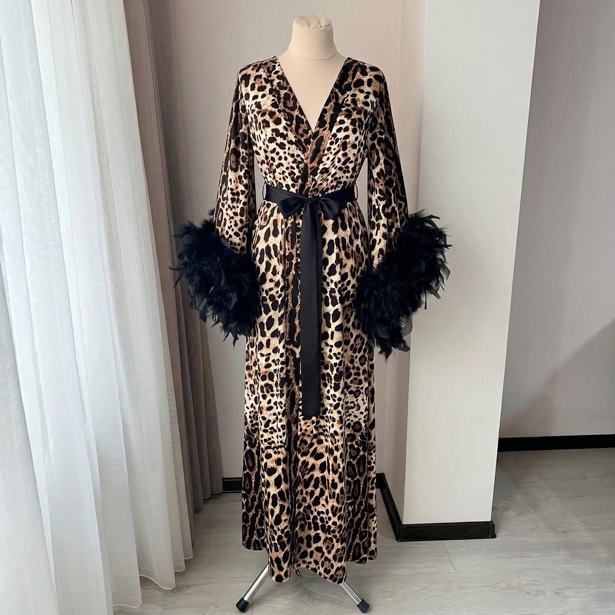 Luxury leopard print robe with feather trim shown in a flowing kimono silhouette