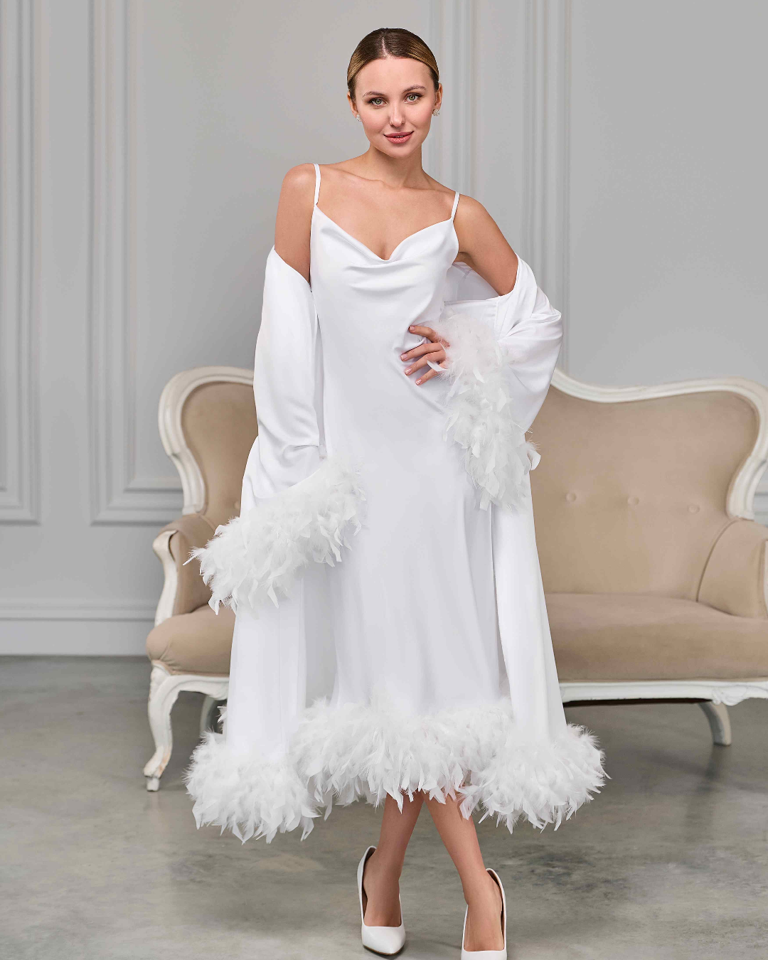white feather-trimmed bridal robe layered over white satin nightgown with spaghetti straps, model posing elegantly