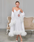 white feather-trimmed bridal robe layered over white satin nightgown with spaghetti straps, model posing elegantly
