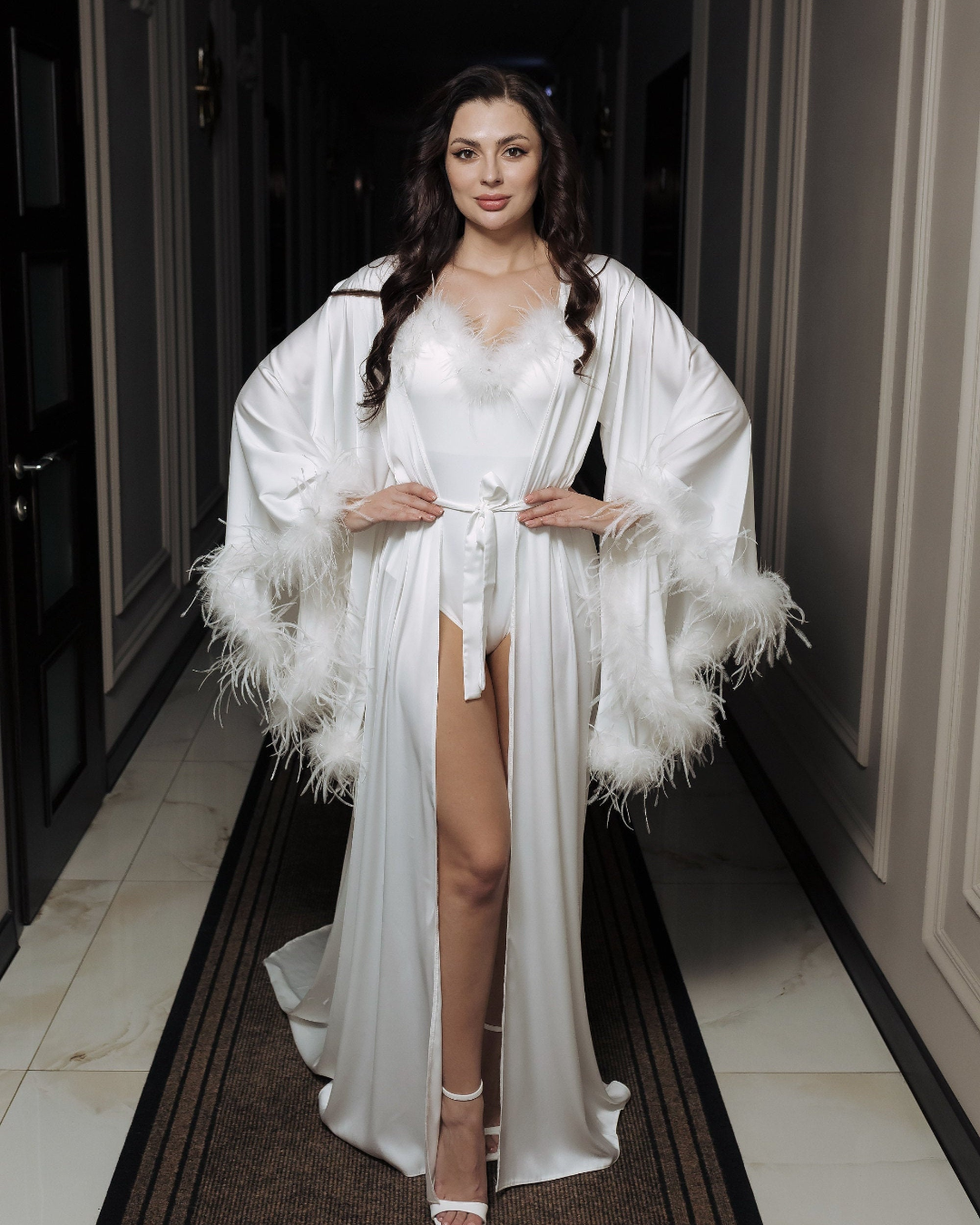 a woman in a long white dress with feathers