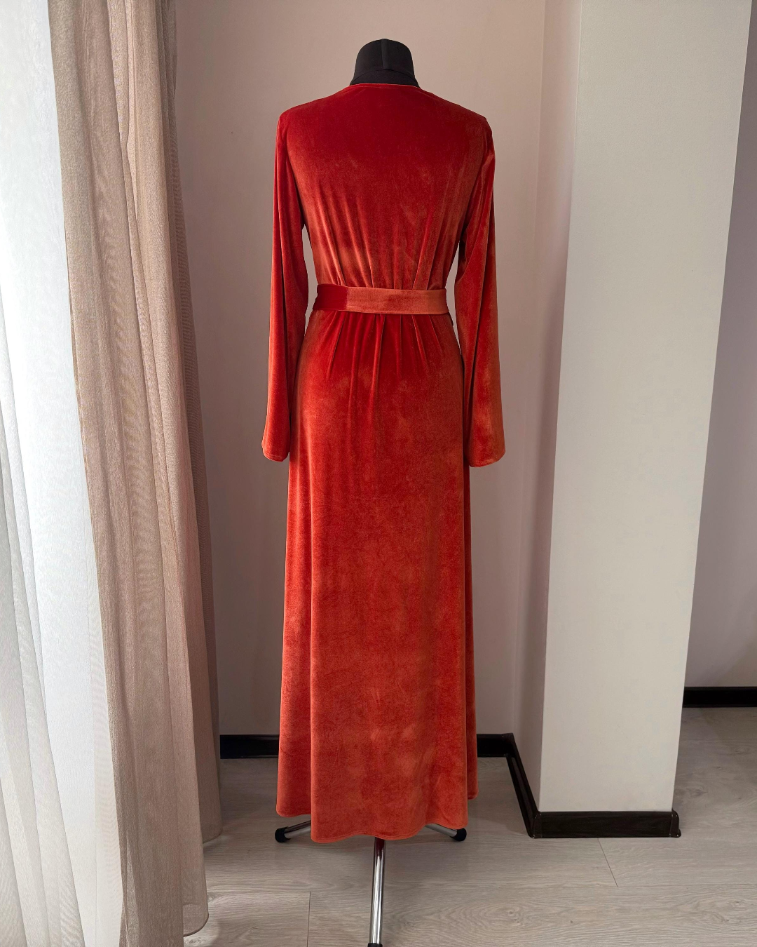 a red dress on a mannequin in a room