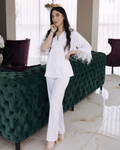 a woman in a white outfit standing next to a green couch