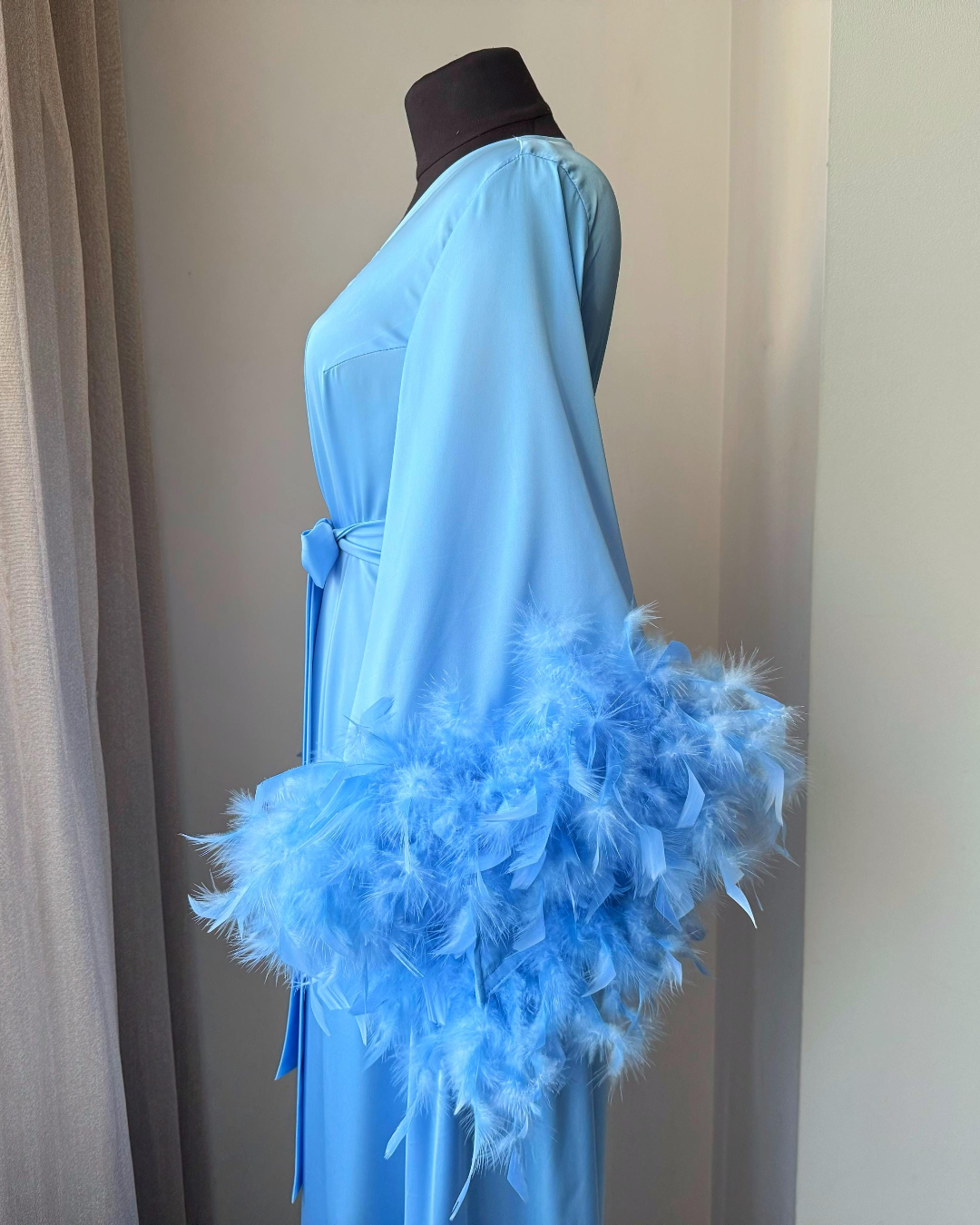 a blue dress with feathers on a mannequin