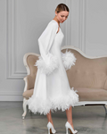 Back and side view of white bridal set with fluffy feathers, model looking down in soft motion