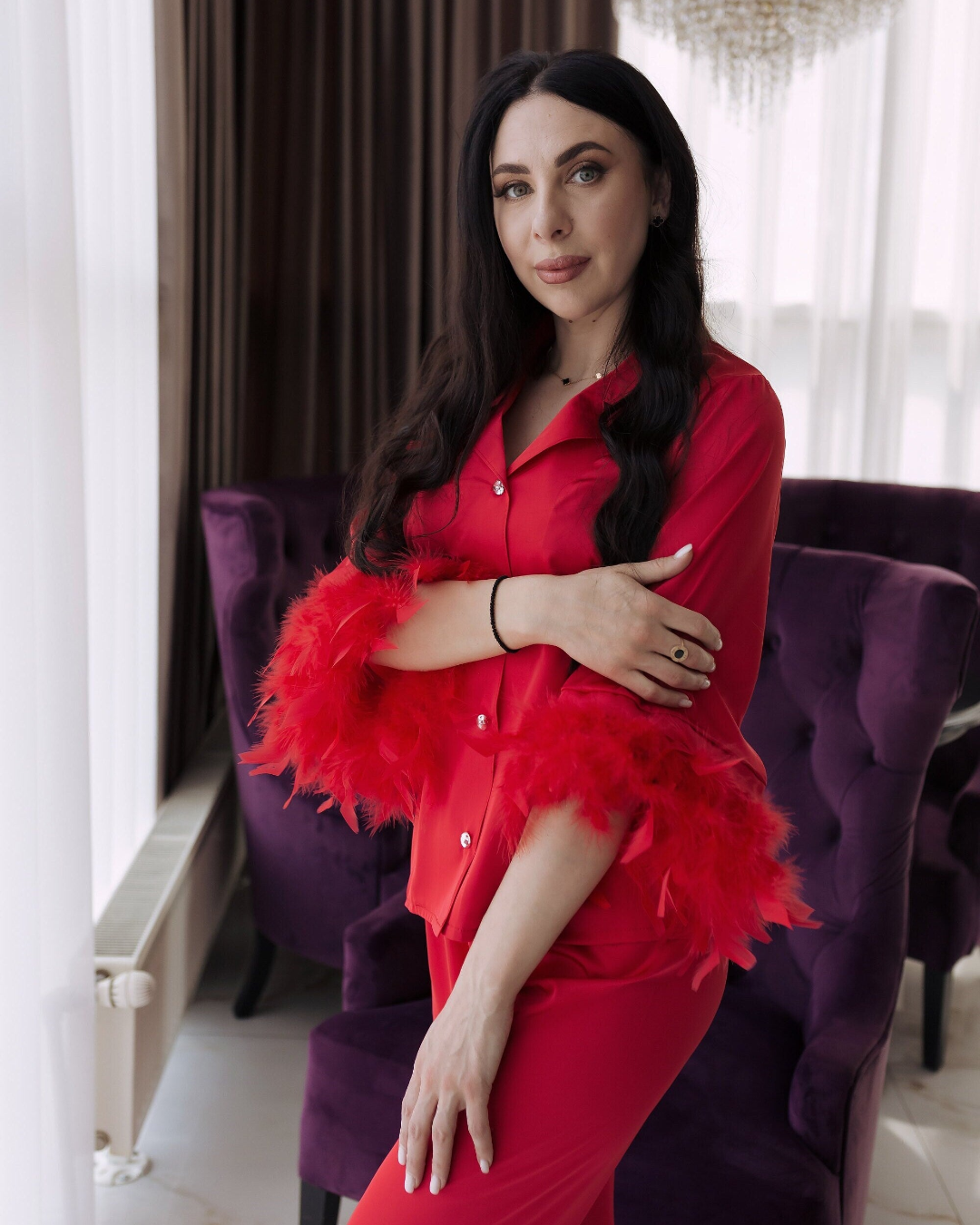 a woman in a red outfit standing in front of a purple chair