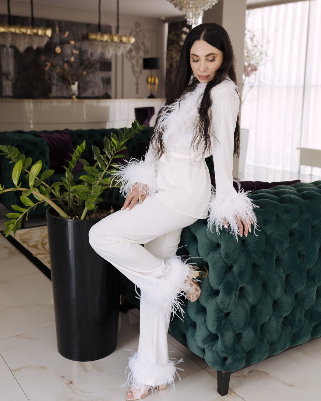 a woman in a white outfit sitting on a green couch