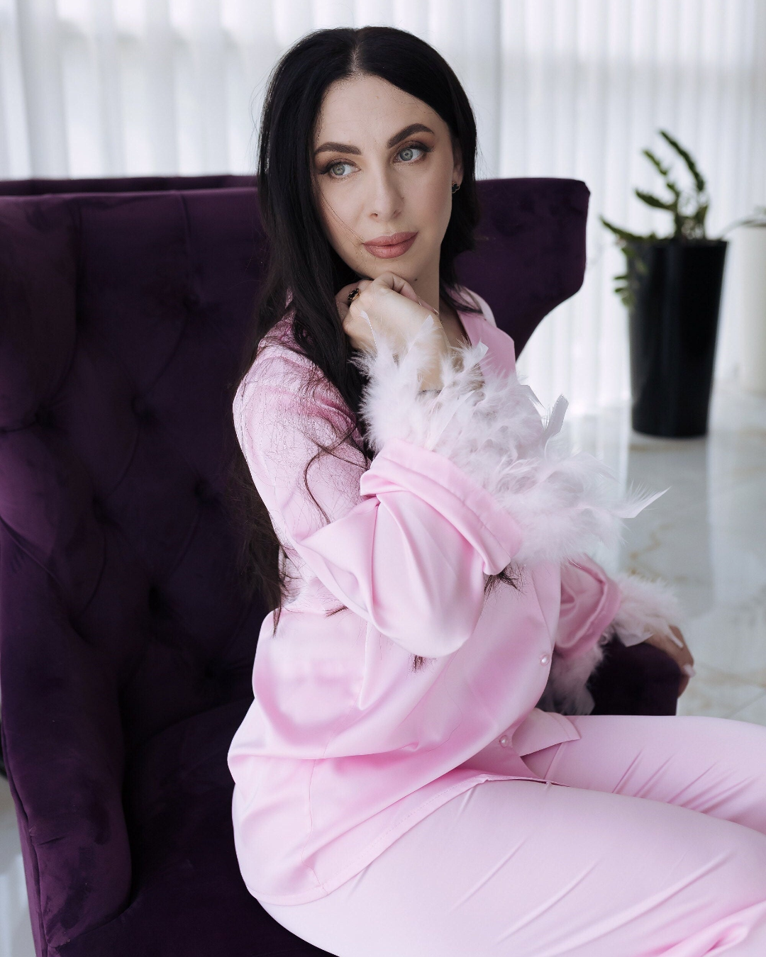 a woman in pink pajamas sitting on a purple chair