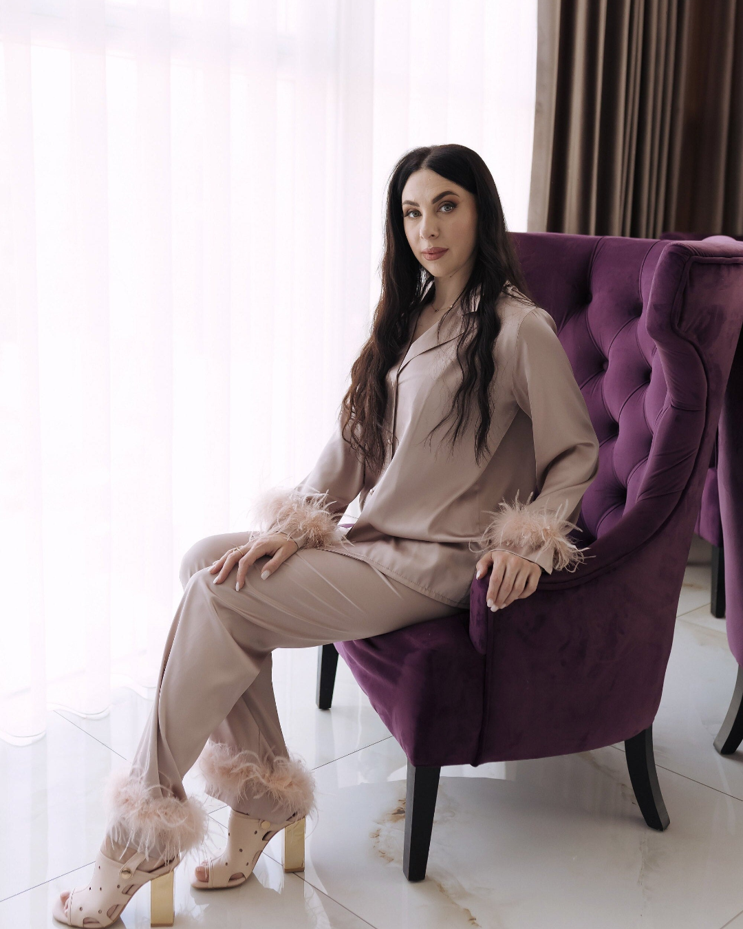 a woman sitting on a purple chair in a room