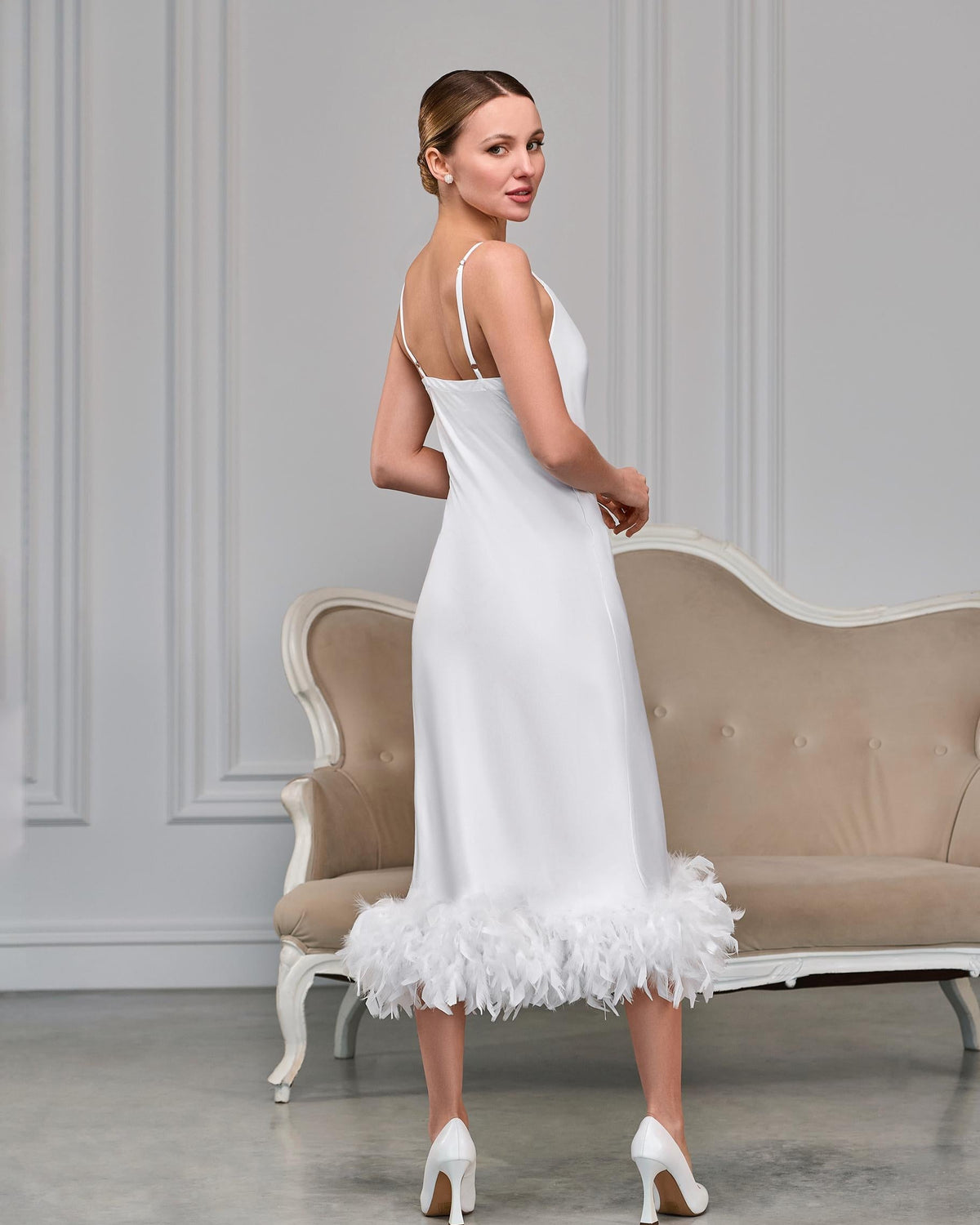 Back view of white satin bridal slip with adjustable spaghetti straps and feather hem