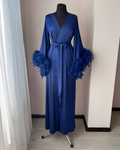 a blue robe with feathers on it sitting on a mannequin