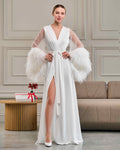 Bride wearing long white robe with sheer beaded sleeves and voluminous ostrich feathers at the cuffs
