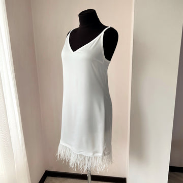 Handmade satin bridal slip dress with ostrich feather trim along the hem