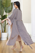 Flowing long robe with intricate geometric design and soft pink details.