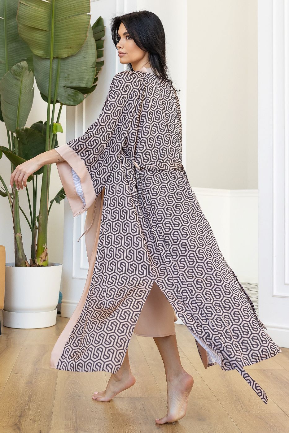 Flowing long robe with intricate geometric design and soft pink details.