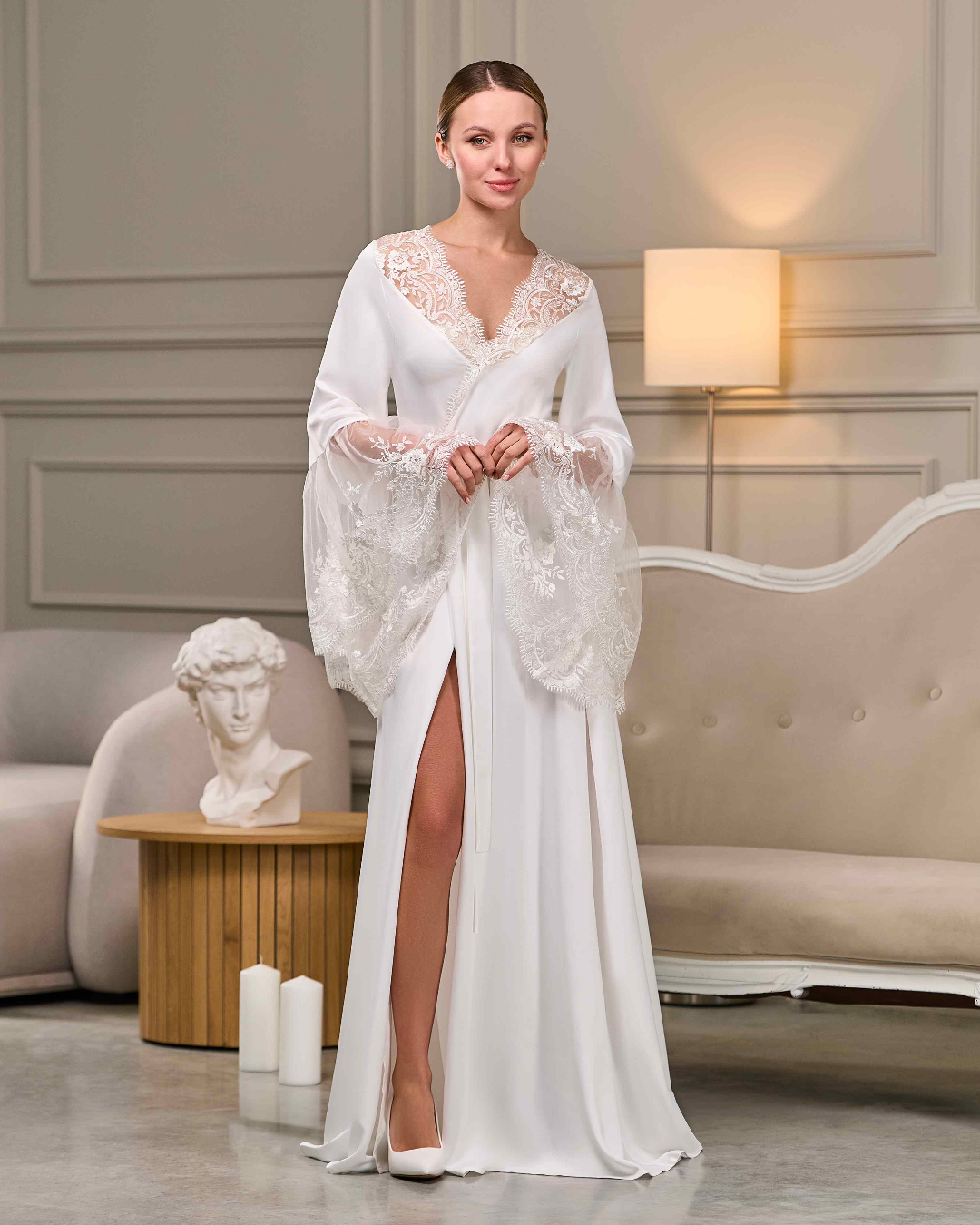 Side view of long bridal robe with lace train and wide sleeves, soft satin texture and floral details