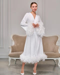 Matching white satin bridal robe with feather cuffs, feather-trimmed hem and waist belt
