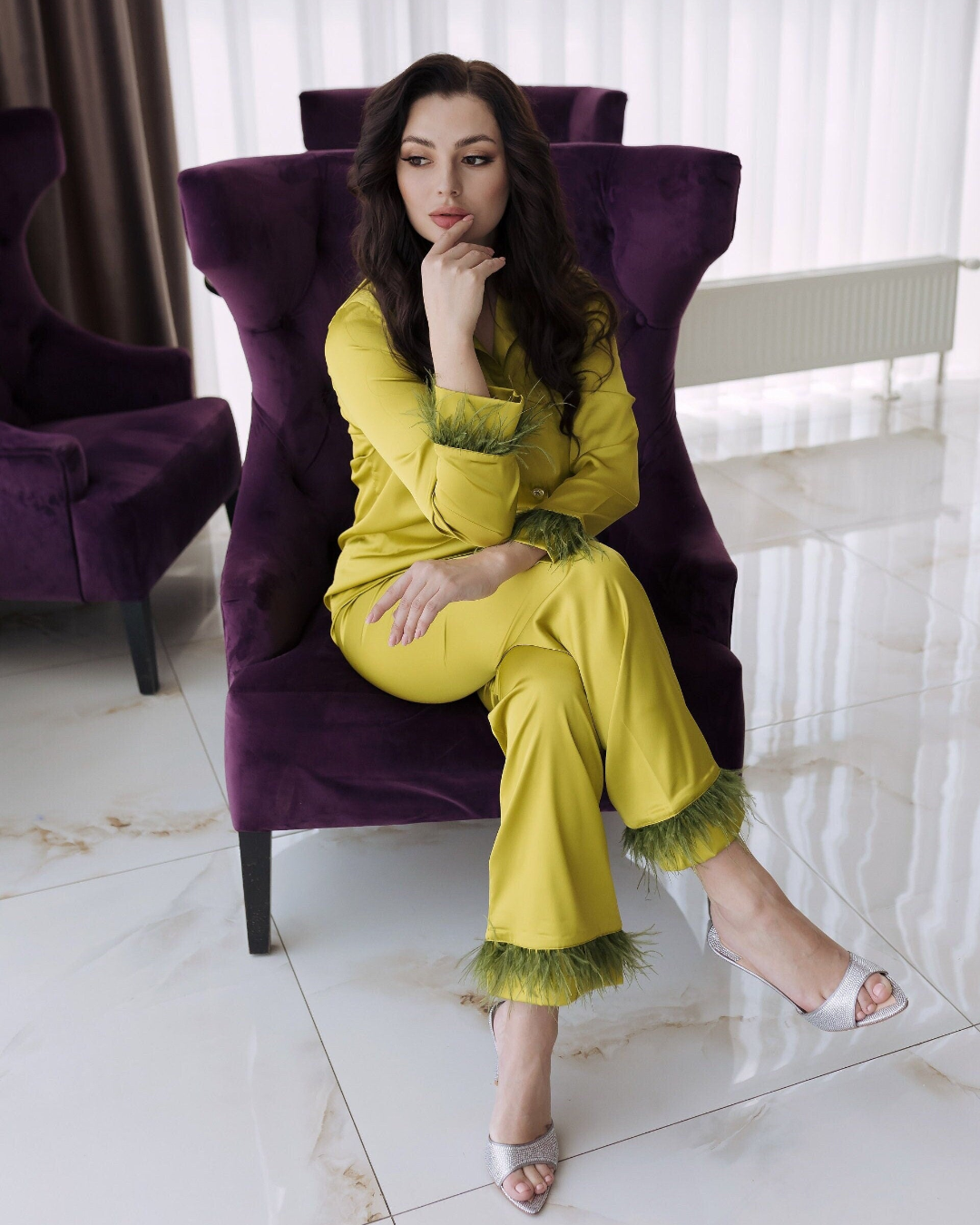 a woman sitting on a purple chair in a room