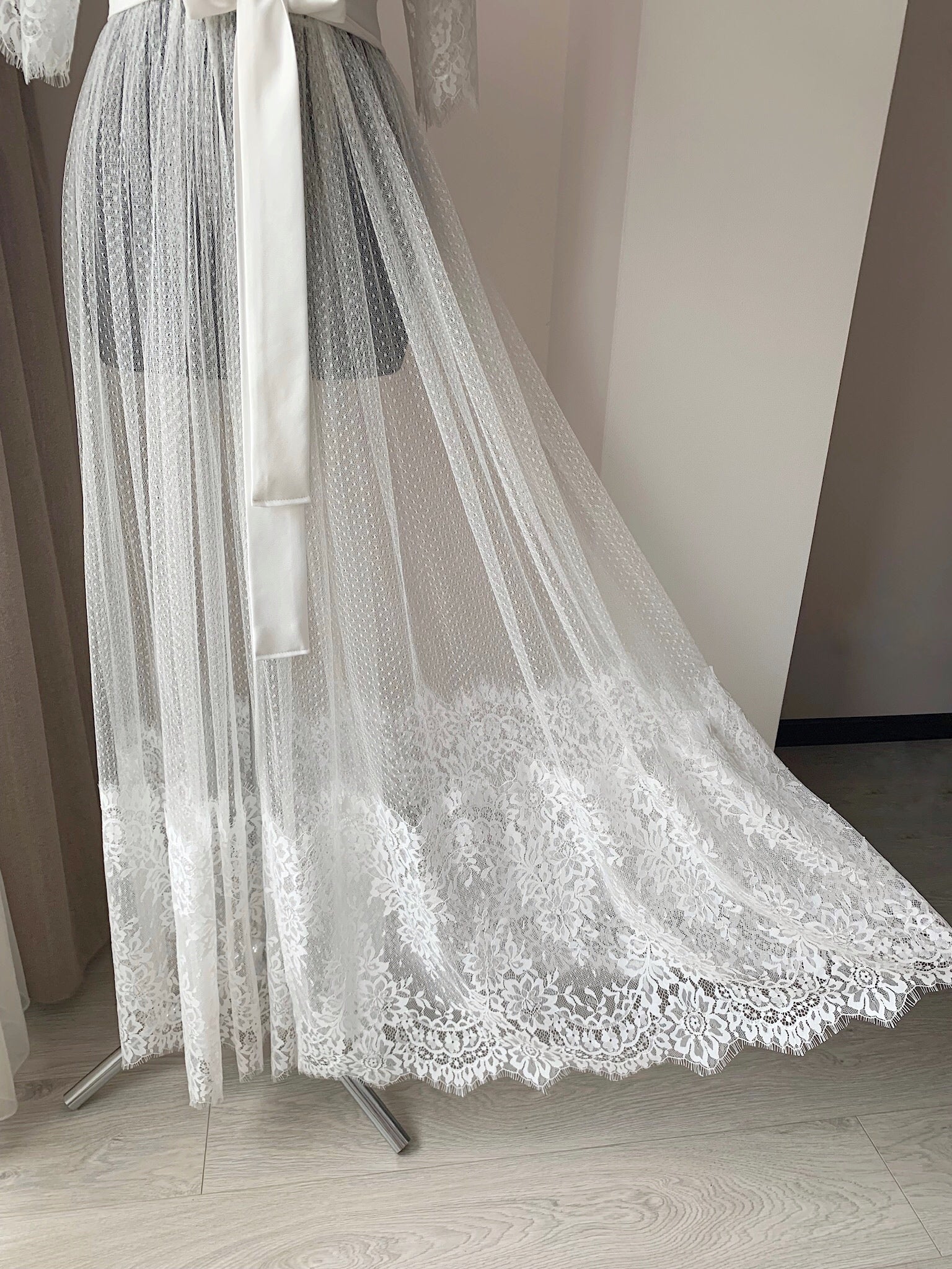 a white dress with a long veil on a mannequin