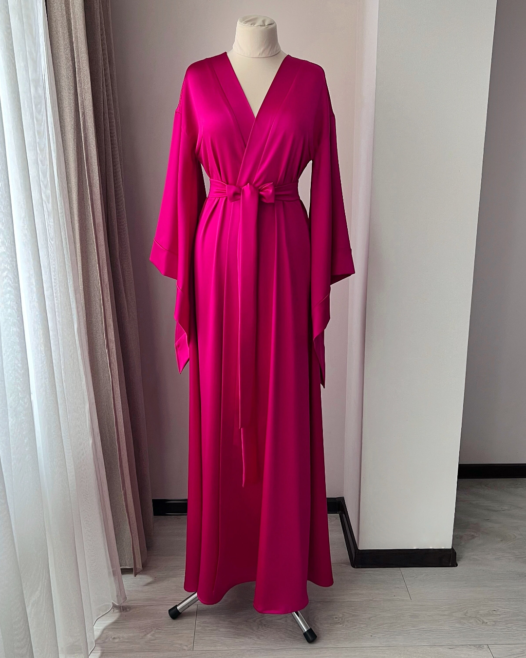 a pink dress on a mannequin in a room