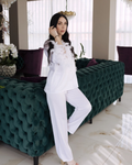 a woman in a white outfit standing next to a green couch