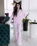 a woman in a pink outfit standing next to a green couch