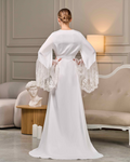 Back view of long white robe with sheer lace sleeves and floor-length train, elegant bridal silhouette